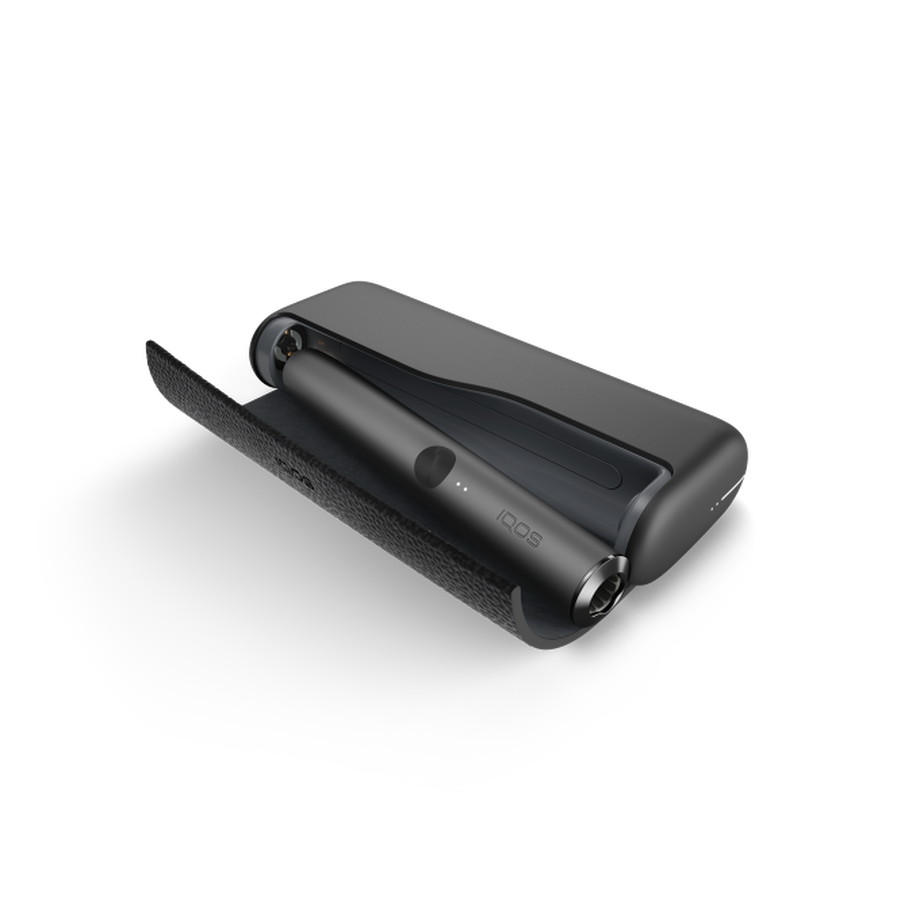 A Obsidian Black  IQOS ILUMA PRIME device inside a holder with the door open. 