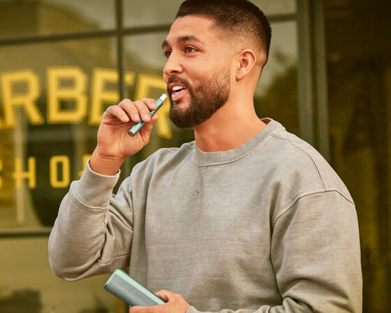 A man holding an IQOS device.