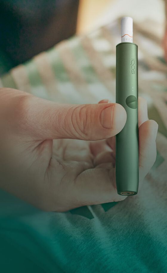 A moss green IQOS ILUMA Holder and Pocket Charger.