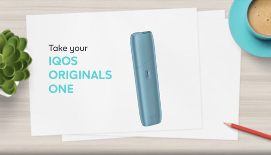 IQOS ORIGINALS ONE heated tobacco device in turquoise next to cable charger.