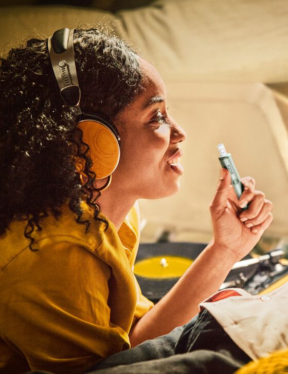 A couple listening to music while using an IQOS device.