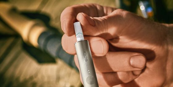A person placing a TEREA stick into an IQOS ILUMA Holder.