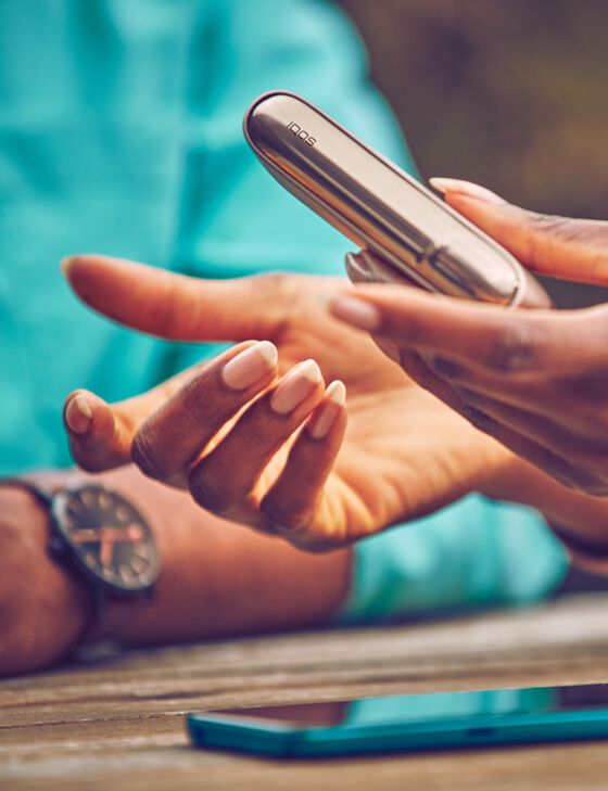 lond woman opening her gold IQOS device