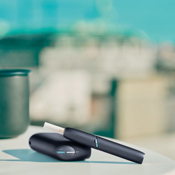 IQOS Originals Duo holder and pocket charger on table.