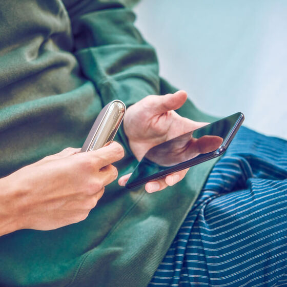 Person registering their IQOS device online by smartphone