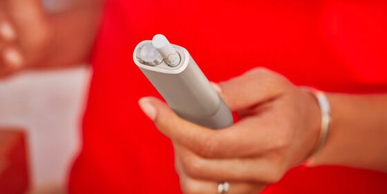 An IQOS ILUMA device and mobile phone.