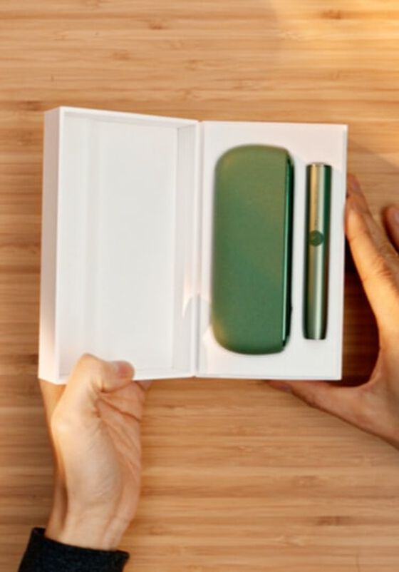 A Moss Green IQOS ILUMA holder and Pocket Charger in a box.